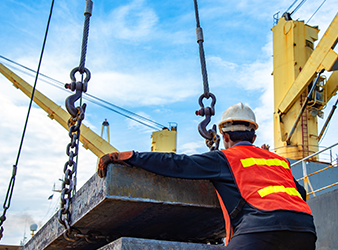 crane using shackles and chains to lift heavy steel frame