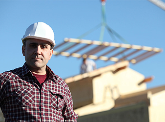 man in hard hat at construction site with rigging lift