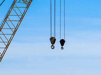 two industrial crane hoist hooks and pulleys