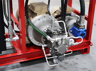 hydraulic pump system with motor and metal pipes on red frame